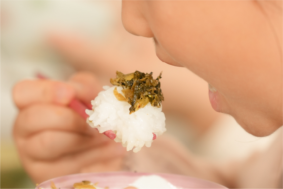 高菜とご飯の旨みと香りを味わう子供
